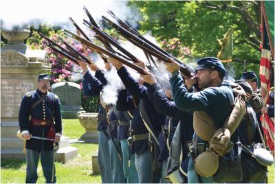 Members of the Irish 28th MA Volunteers fired their weapons during a salute at last year’s Memorial Day observances in Cedar Grove Cemetery. 	Chris Lovett photo
